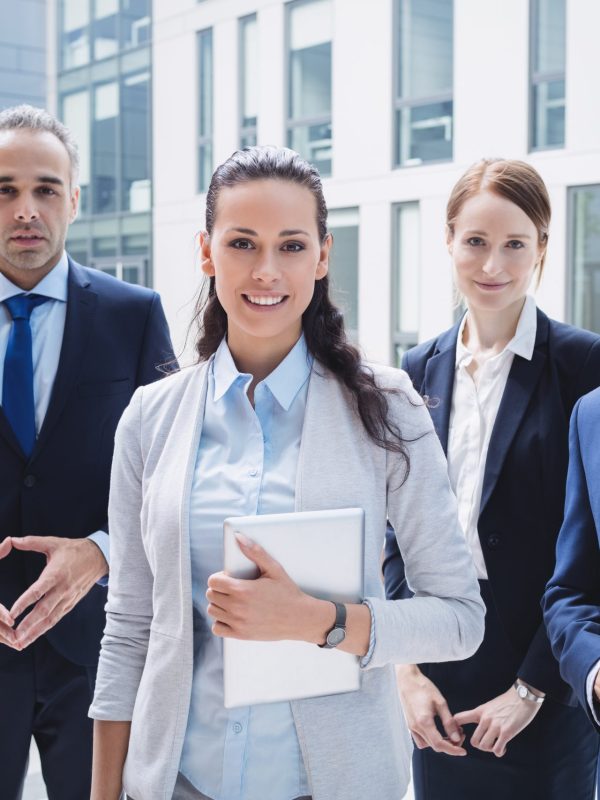 Portrait of confident businesspeople standing outside office building